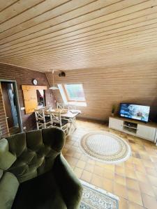 a living room with a couch and a tv and a table at Ferienhaus Liesel in Dornumersiel