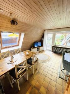 a dining room with a wooden table and chairs at Ferienhaus Liesel in Dornumersiel
