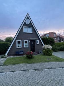 a house with a clock on the top of it at Ferienhaus Liesel in Dornumersiel