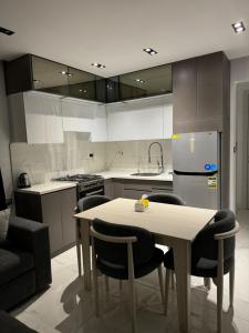 a kitchen with a table and chairs and a refrigerator at Helnan portfouad hotel in Chantier Island +4 photos