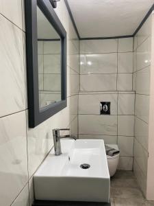 a white bathroom with a sink and a toilet at Villa Georgia in Potos