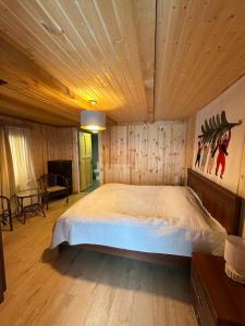 a bedroom with a large bed with a wooden ceiling at კოტეჯი ბახმაროში WoodenHouse Sunrise in Bakhmaro