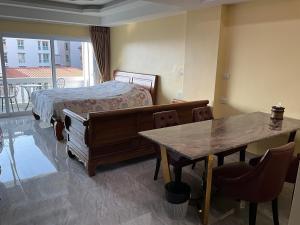 a bedroom with a bed and a table with chairs at Pattaya Tower EVO 401 in Pattaya Central