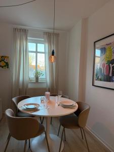 a dining room table with chairs and a table and a window at Stadt Flair in Eisenach +5 photos