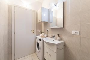 a bathroom with a washing machine and a sink at Garden Dream in Valle di Cadore +10 photos