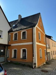 an orange and white building on a street at Haus mit Herz in Sulzbach-Rosenberg