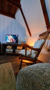 a rocking chair in a living room with a television at Kucica na Dunavu in Smederevo