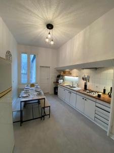 a large kitchen with a table in the middle at L'Appartement Privilège - 4 chambres - Coeur d'Angers, Spacieux et Élégant in Angers