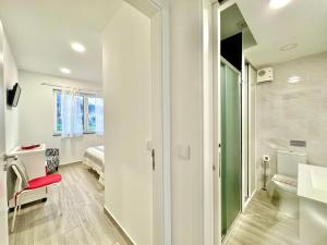 a bathroom with a toilet and a bed in a room at LOFT AS CASETAS PEREGRINOS in Rosal +63 photos