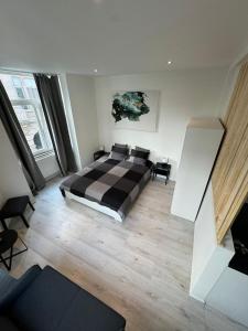 ブリュッセルにあるBrussels Harmony Stayのベッドルーム1室(チェック入りの毛布付きのベッド1台付)