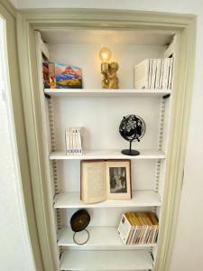 a book shelf filled with books and a lamp at L'Appartement Privilège - 4 chambres - Coeur d'Angers, Spacieux et Élégant in Angers +7 photos