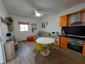een keuken en woonkamer met een tafel en stoelen bij Buenas Olas Tenerife in Costa Del Silencio