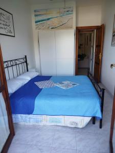 ヴィッラシミーウスにあるCasa vacanza Villasimiusの青い掛け布団が敷かれたベッドのある寝室