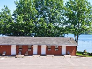 a building with benches in front of a lake at Lakeshore Motel Ice Lake in Iron River +29 photos
