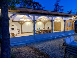 a white house with a blue roof and a tree at Rustic Inn bed and breakfast in Budeşti