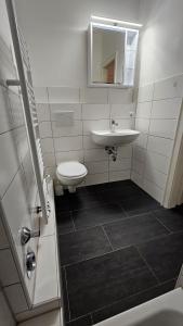 a white bathroom with a sink and a toilet at Zentral gelegenes Apartment Nähe MHH und Eilenriede in Hannover