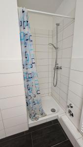 a shower with a blue and white shower curtain in a bathroom at Zentral gelegenes Apartment Nähe MHH und Eilenriede in Hannover