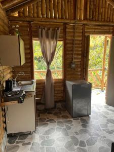 a kitchen with a curtain in a room with a stove at Cabañas Amanvari in El Retiro +23 photos