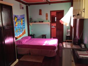 ein Schlafzimmer mit einem lila Bett in einem Zimmer in der Unterkunft Italian Guesthouse in Gros Islet