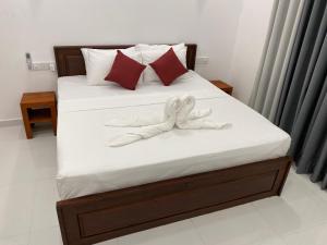 a bed with two white towels on it at Lavish in Weligama