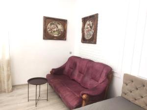a living room with a red couch and two pictures at Центр in Vinnytsya