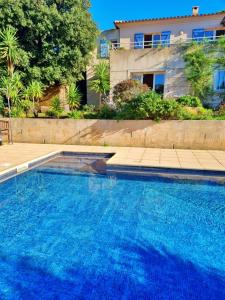 a large blue swimming pool in front of a house at Agréable 2 pièces dans villa avec piscine in Calvi