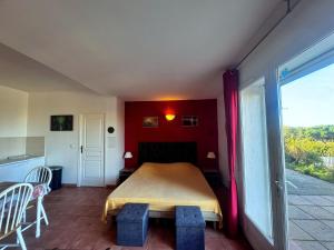 a bedroom with a bed with a red wall at Agréable 2 pièces dans villa avec piscine in Calvi