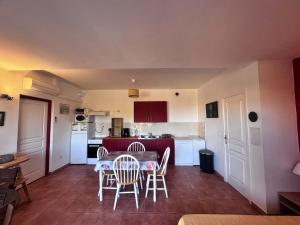 a kitchen and dining room with a table and chairs at Agréable 2 pièces dans villa avec piscine in Calvi