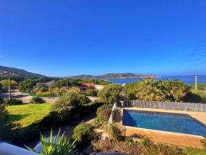 a villa with a swimming pool and a view of the ocean at Agréable 2 pièces dans villa avec piscine in Calvi
