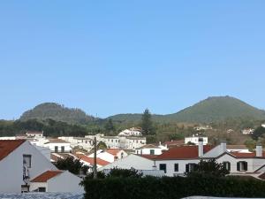 a town with white houses and mountains in the background at Casa Cayenne in Ponta Delgada