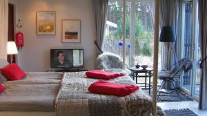 una camera da letto con un letto con cuscini rossi di Ängshyddan B&B a Yngsjö