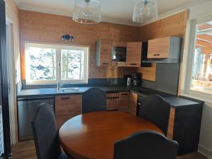 a kitchen with a table and chairs and a sink at Chalet insolite en Forêt in Ranspach