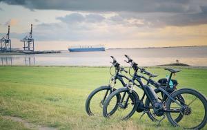 two bikes parked in a field next to the water at Direkt am Deich! Ferienwohnung de Prigg in Dorum Neufeld
