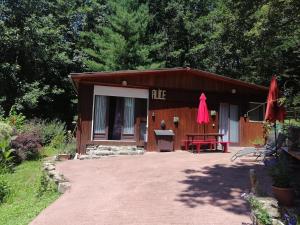 a small cabin with a red bench in front of it at Chalet Alice in LʼHôpital-Saint-Blaise