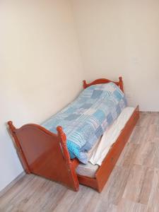a small bed with a wooden frame in a room at Rizzo República Siria in Bahía Blanca
