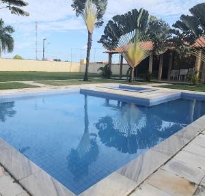 a swimming pool in a yard with palm trees at Accogliente chalet rustico in Maceió +7 photos