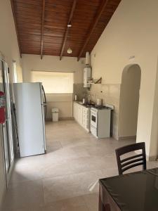 a large kitchen with a refrigerator and a table at Cabaña Puente B 1 in El Calafate