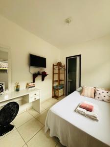 a bedroom with a bed and a desk and a television at Microcasa Aconchego Paraty in Paraty +5 photos