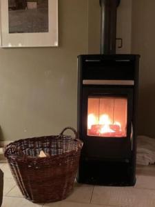 a black stove with a basket in front of it at Villa Sonnenpiste in Kötschach