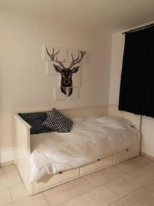 a bedroom with a bed with a deer head on the wall at Villa Sonnenpiste in Kötschach