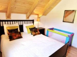 a bedroom with a large bed with colorful pillows at Villa Sonnenpiste in Kötschach