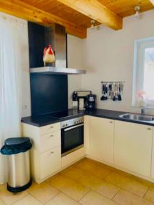 a kitchen with white cabinets and a black counter top at Villa Sonnenpiste in Kötschach