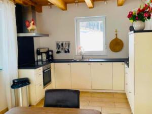 a kitchen with white cabinets and a sink and a window at Villa Sonnenpiste in Kötschach