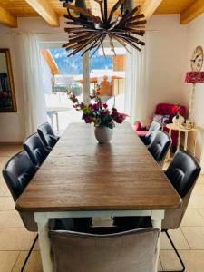 a dining room table with chairs and a vase with flowers at Villa Sonnenpiste in Kötschach +27 photos
