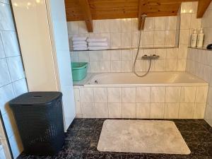 a bathroom with a tub and a trash can at Villa Sonnenpiste in Kötschach