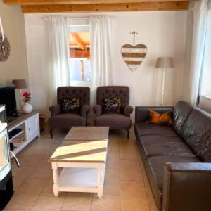 a living room with a couch and chairs and a table at Villa Sonnenpiste in Kötschach