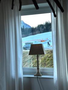 a window with a lamp and a view of a beach at Villa Sonnenpiste in Kötschach