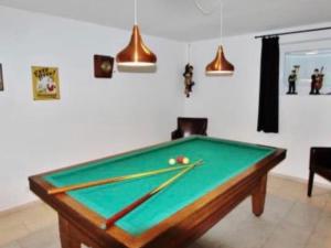a room with a pool table with cue sticks at Villa Sonnenpiste in Kötschach