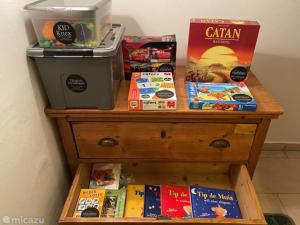a shelf with books and games on a dresser at Villa Sonnenpiste in Kötschach