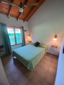a bedroom with a bed and a ceiling fan at Cabaña Los Angeles in Villa General Belgrano